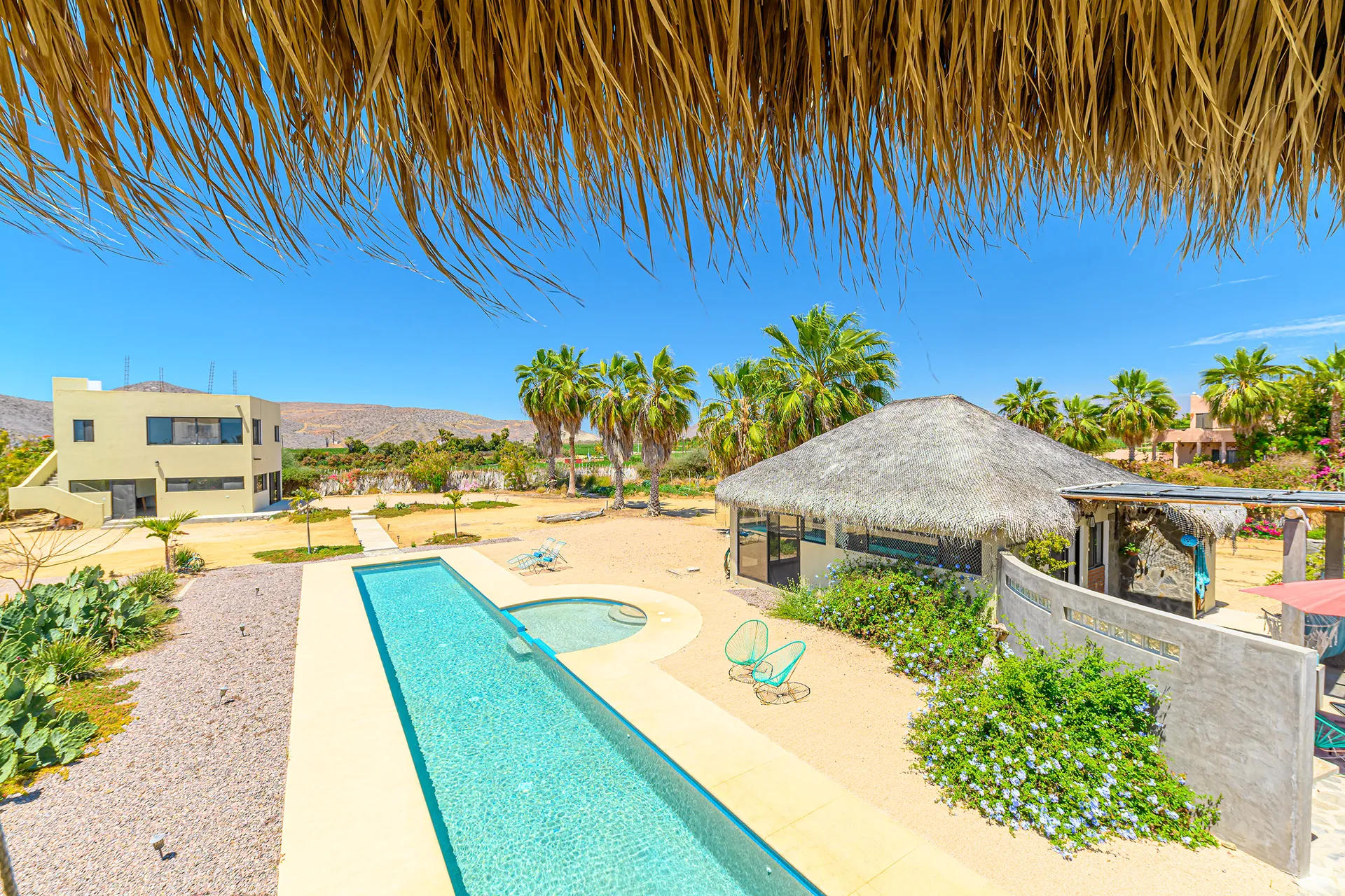 One acre divided into two lots, two one-bedroom casitas, a one-bedroom, one-bath house, yoga or art studio, sixty-foot heated lap pool, community kitchen with full bath and barbecue area.